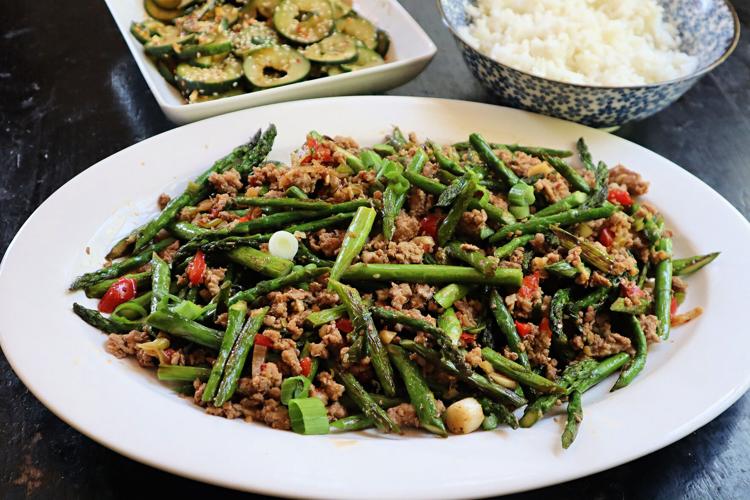 Thin stalks of spring asparagus are blistered, then tossed with ground pork, garlic, ginger and soy sauce.